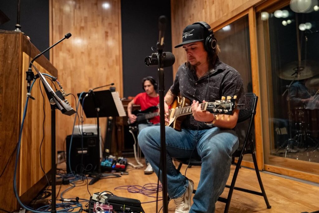 Colin Stough in s studio singing in mic